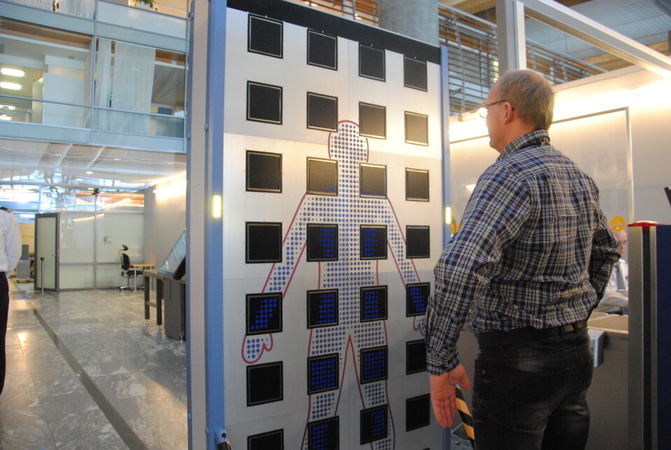 OPPSTILLING: Bjørn Erik Larsen demonstrerer en av de fire nye securityscannerne ved Oslo Lufthavn. (Foto: Stine Marie Hagen)