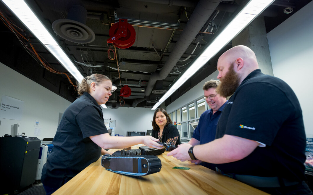 Cyra Richardson (left) stands opposite the workbench from (right to left) Barron Barnett, Sean Kelly and Marlina Hales as they examine a robot snake. All are Microsoft employees except for Kelly, who is a consultant. Credit: Microsoft