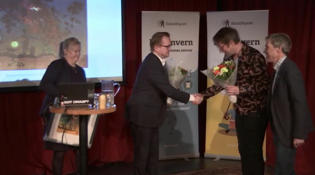 HEDER: Atle Alvheim og Ørnulf Risnes fra NSD mottar prisen av Kjartan Almenning, politisk rådgiver i Kunnskapsdepartementet. (Foto: Skjermbilde fra videoverføring)